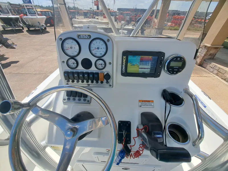 Slide: The Image of The image shows the helm of a 2011 Sea Hunt XP21 boat with instruments and a Lowrance display. - 27