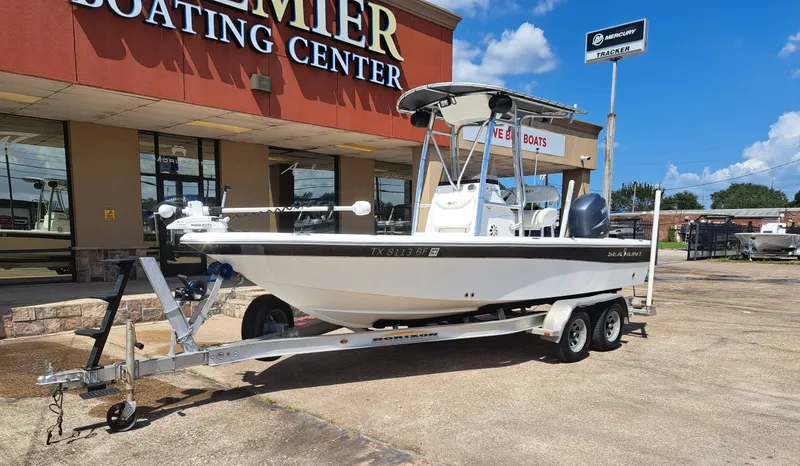 Slide: The Image of A white 2011 Sea Hunt XP21 boat on a trailer outside a boating center. - 7