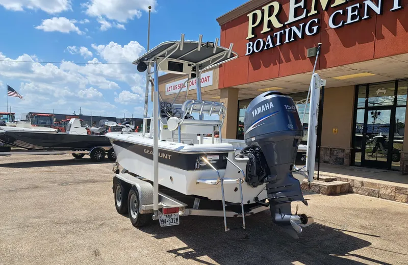 Slide: The Image of A 2011 Sea Hunt XP21 boat with a Yamaha outboard motor on a trailer outside a boating center. - 6