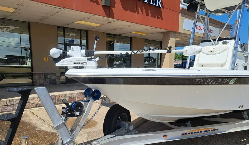 Slide: The Image of A white boat, a 2011 Sea Hunt XP21, is on a trailer in front of a building. - 8