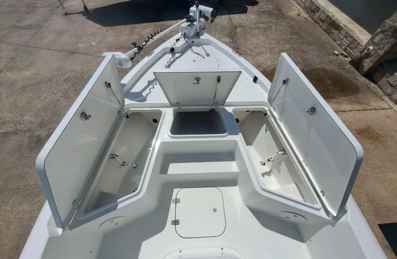 Slide: The Image of The image shows the bow of a Sea Hunt XP21 boat with open storage compartments. - 14