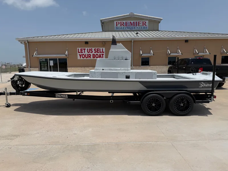 The Image of A 2027 Shoalwater 23 CAT RSD boat on a trailer in front of a boating center. - 1