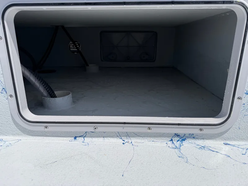 Slide: The Image of An open storage compartment on a boat with blue marbling and visible pipes. - 14