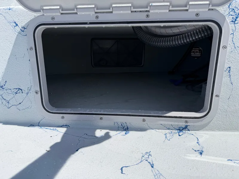 Slide: The Image of An open storage compartment on a boat with blue marbling and a hose inside. - 15