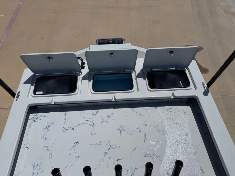 Slide: The Image of The image shows the deck of a Shoalwater 23 CAT RSD boat with three open storage compartments. - 22