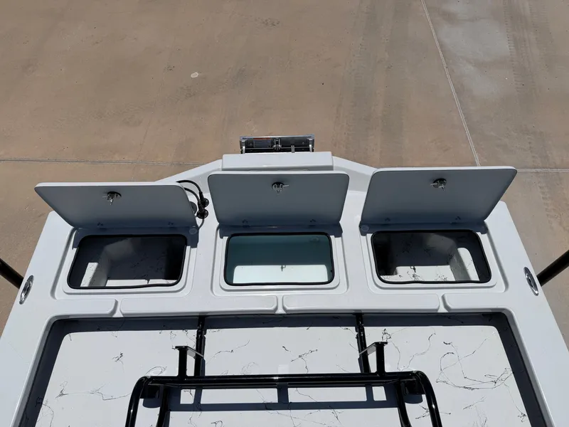 Slide: The Image of The image shows the deck of a Shoalwater 23' Catamaran with three open storage compartments. - 21
