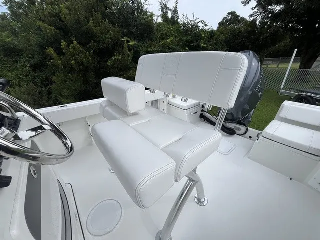 Slide: The Image of The image shows the cockpit of a Parker 210 Coastal boat with white upholstery and a helm station. - 9