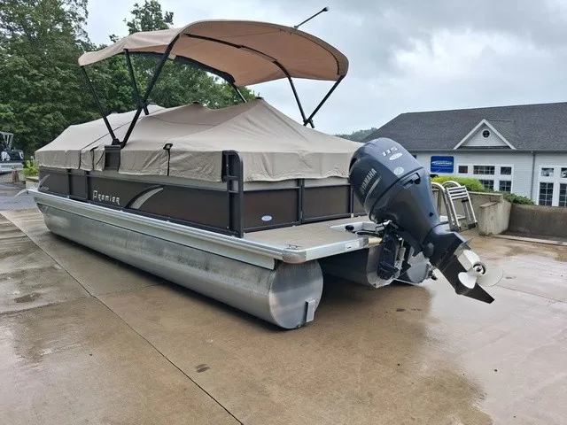 Slide: The Image of A 2015 Premier Sunsation RF 230 pontoon boat with a Yamaha outboard motor, covered and on a wet dock. - 19