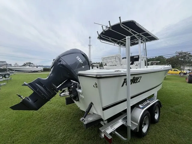 Slide: The Image of Parker 210 Coastal 2027 with Yamaha outboard motor on a trailer, set on a grassy field. - 4