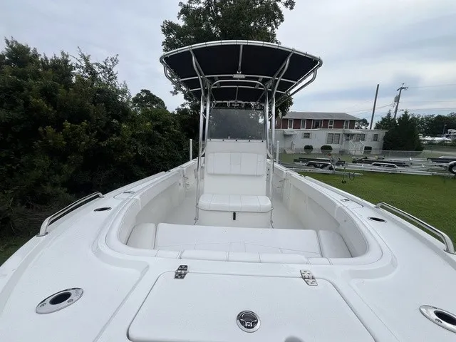 Slide: The Image of The image shows a Parker 210 Coastal boat with a white seating area and a black sunshade. - 6