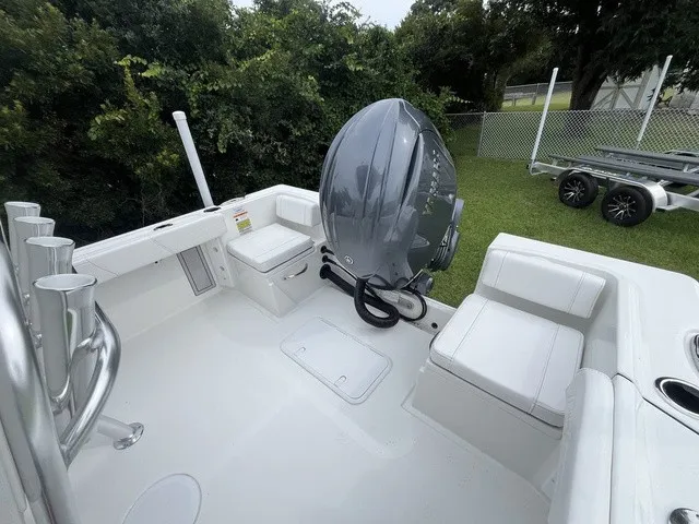 Slide: The Image of The image shows the stern of a Parker 210 Coastal boat with an outboard motor and seating. - 10