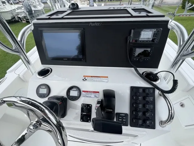 Slide: The Image of The image shows the helm of a Parker 210 Coastal boat with various instruments and a screen. - 8