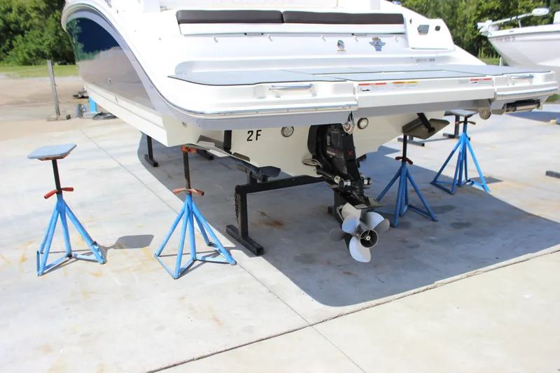 Slide: The Image of 2019 Sea Ray SDX 290 boat on stands, showcasing the stern and propeller. - 11