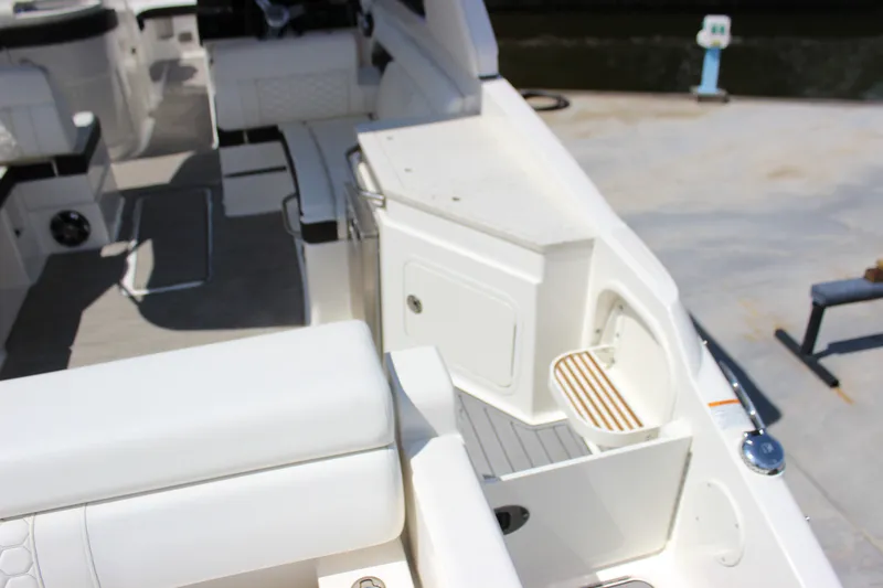 Slide: The Image of 2019 Sea Ray SDX 290 boat interior with white seating and storage compartments. - 33