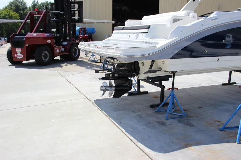 Slide: The Image of 2019 Sea Ray SDX 290 boat on stands, with forklift nearby in a marina setting. - 23