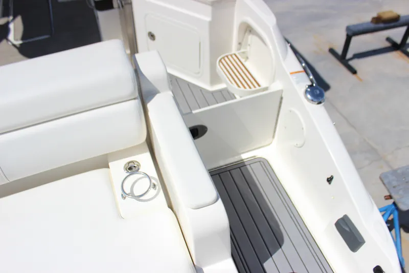 Slide: The Image of 2019 Sea Ray SDX 290 boat interior with white seating and gray flooring. - 34