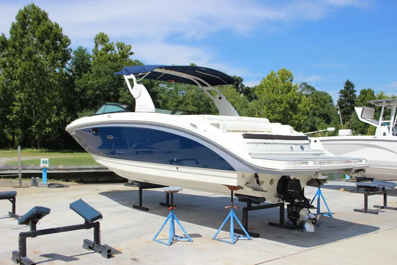 Slide: The Image of 2019 Sea Ray SDX 290 boat on stands, blue and white design, outdoor setting. - 9