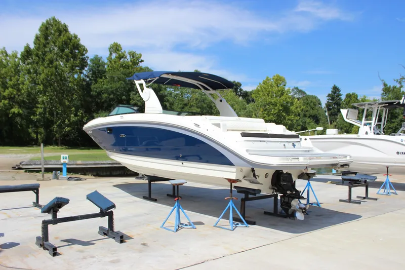 Slide: The Image of 2019 Sea Ray SDX 290 boat on stands, blue and white, outdoors. - 10