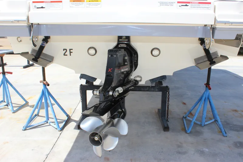 Slide: The Image of Rear view of 2019 Sea Ray SDX 290 boat on stands, showcasing propeller and engine. - 12