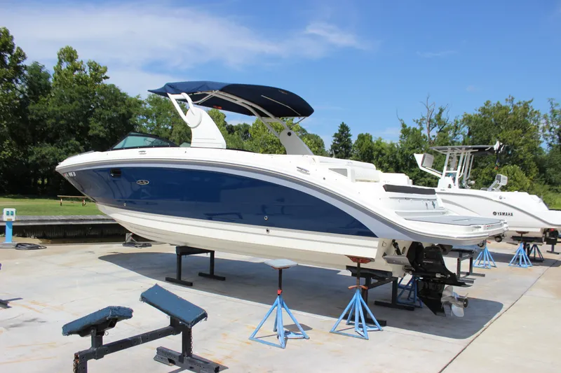 Slide: The Image of 2019 Sea Ray SDX 290 boat on stands, blue and white design, outdoor setting. - 17