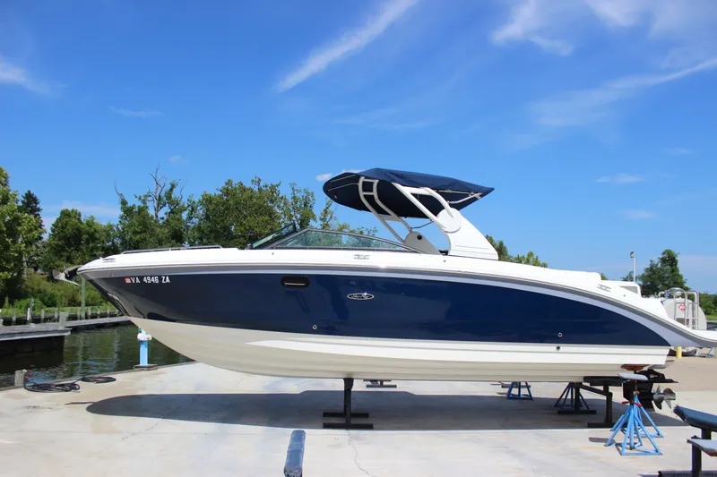 Slide: The Image of 2019 Sea Ray SDX 290 boat on stands, blue hull, sunny day. - 19