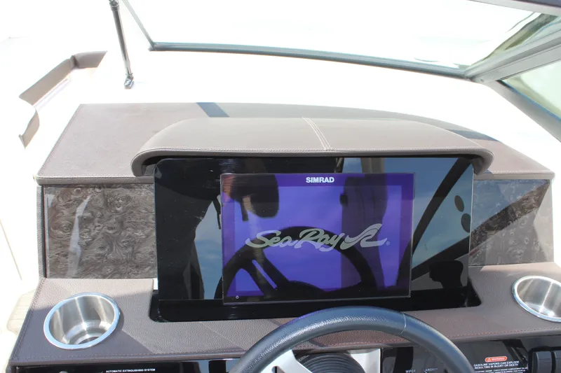 Slide: The Image of 2019 Sea Ray SDX 290 dashboard with Simrad display and cup holders. - 46