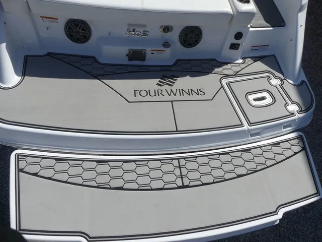 Slide: The Image of The image shows the stern of a 2021 Four Winns HD3 Surf boat with gray decking. - 29