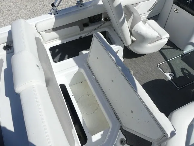 Slide: The Image of The image shows the interior of a 2021 Four Winns HD3 Surf boat with white seating and storage. - 25