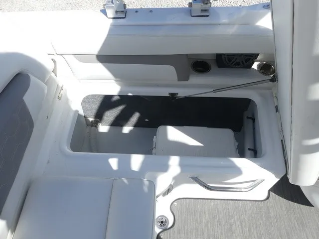 Slide: The Image of An open storage compartment on a boat with gray flooring and white upholstery. - 26