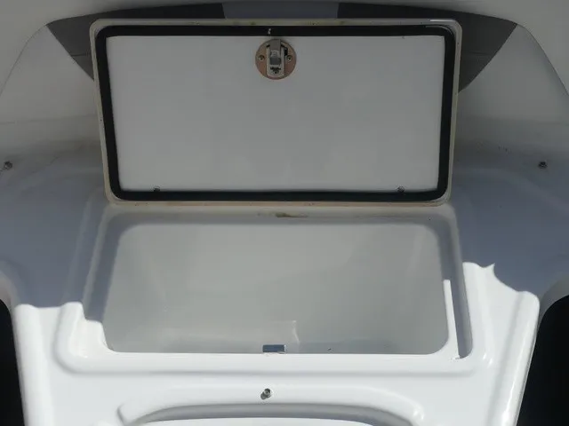 Slide: The Image of An open storage compartment on a boat with a white lid and latch. - 19