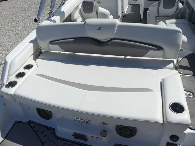 Slide: The Image of The image shows the stern of a 2021 Four Winns HD3 Surf boat with white upholstery. - 28