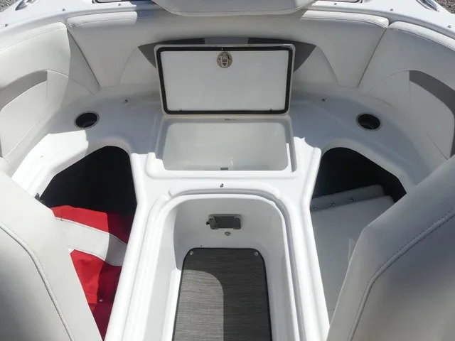 Slide: The Image of The image shows the bow area of a 2021 Four Winns HD3 Surf with white upholstery and storage. - 18