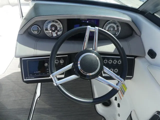 Slide: The Image of The image shows the dashboard of a 2021 Four Winns HD3 Surf boat with a modern steering wheel and instruments. - 14