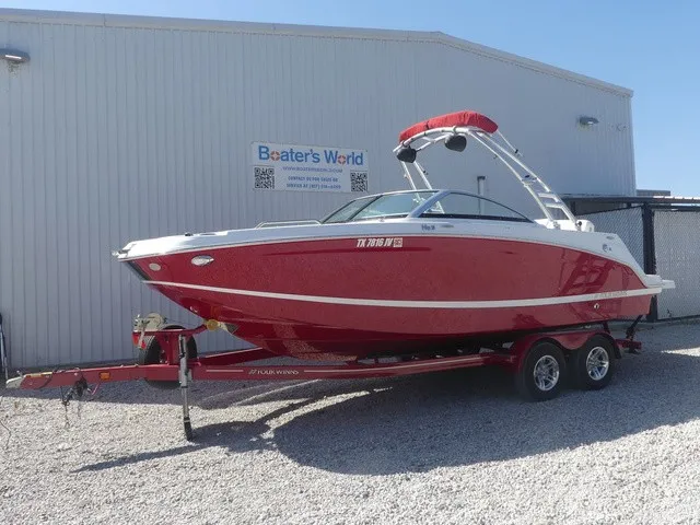 The Image of A red 2021 Four Winns HD3 Surf boat on a trailer in front of a building. - 1