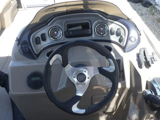 Slide: The Image of The image shows the helm of a 2020 Sun Tracker SportFish 22 DLX with a modern steering wheel and gauges. - 16