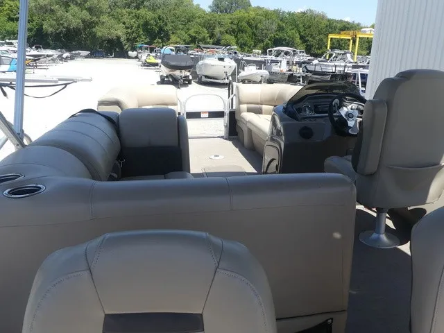 Slide: The Image of The image shows the interior of a Sun Tracker SportFish 22 DLX pontoon boat with beige seating. - 18