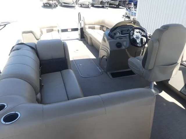 Slide: The Image of The image shows the interior of a 2020 Sun Tracker SportFish 22 DLX with beige seating and a helm. - 17