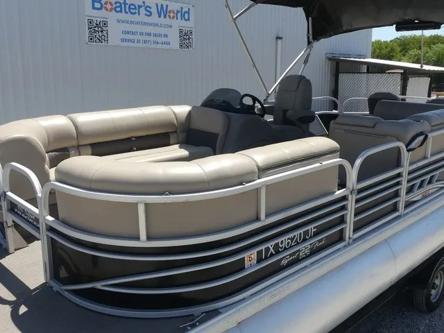 Slide: The Image of A 2020 Sun Tracker SportFish 22 DLX pontoon boat with beige seating and a helm station. - 14
