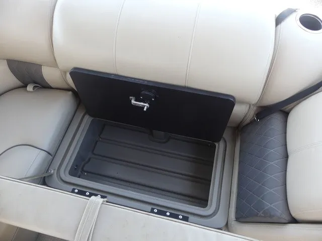 Slide: The Image of A seating area with an open storage compartment in a Sun Tracker SportFish 22 DLX boat. - 31