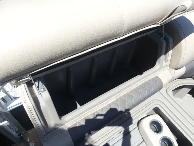 Slide: The Image of An open storage compartment on a boat with cushioned seating and cup holders. - 34