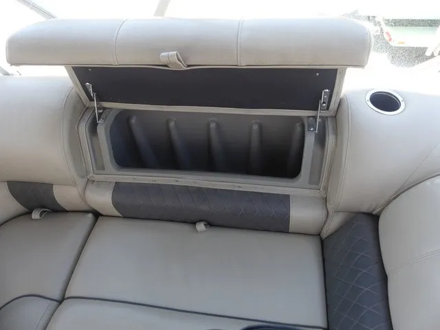 Slide: The Image of An open storage compartment in a cushioned seat with a cup holder. - 32