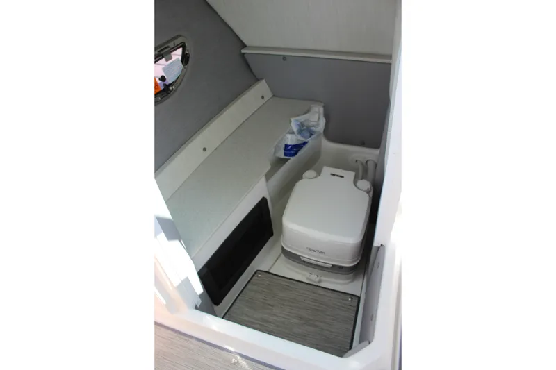 Slide: The Image of 2024 Cobalt R6 Outboard boat interior with compact marine toilet and storage space. - 25