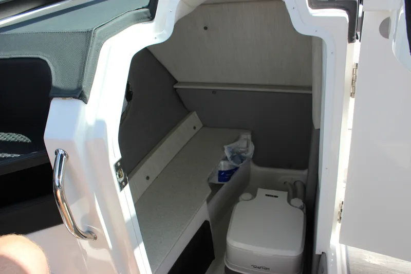 Slide: The Image of 2024 Cobalt R6 Outboard boat interior with compact toilet and storage area. - 24