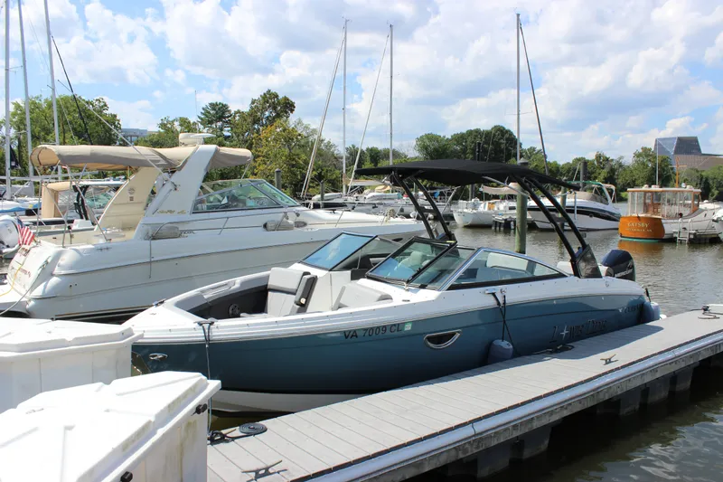 Slide: The Image of 2024 Cobalt R6 Outboard boat docked at a marina with other vessels. - 5