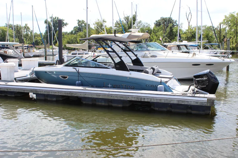 Slide: The Image of 2024 Cobalt R6 Outboard boat docked at a marina with other vessels. - 4