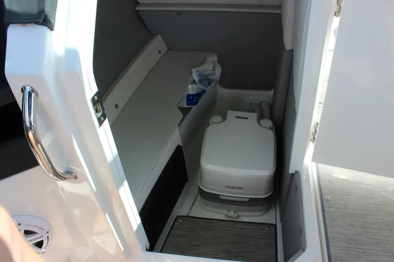 Slide: The Image of Interior of 2024 Cobalt R6 Outboard boat featuring a compact marine toilet. - 23