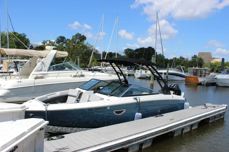 Slide: The Image of 2024 Cobalt R6 Outboard boat docked at a marina under a clear blue sky. - 2