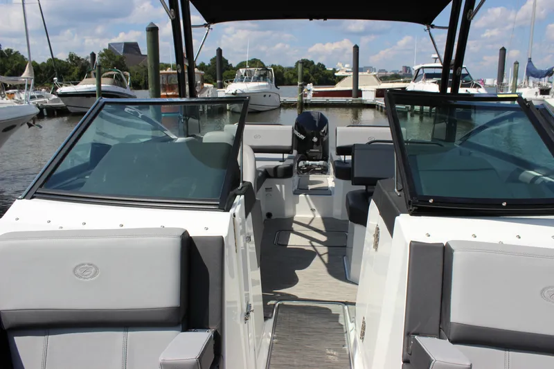 Slide: The Image of 2024 Cobalt R6 Outboard boat interior at marina, showcasing seating and windshield. - 18