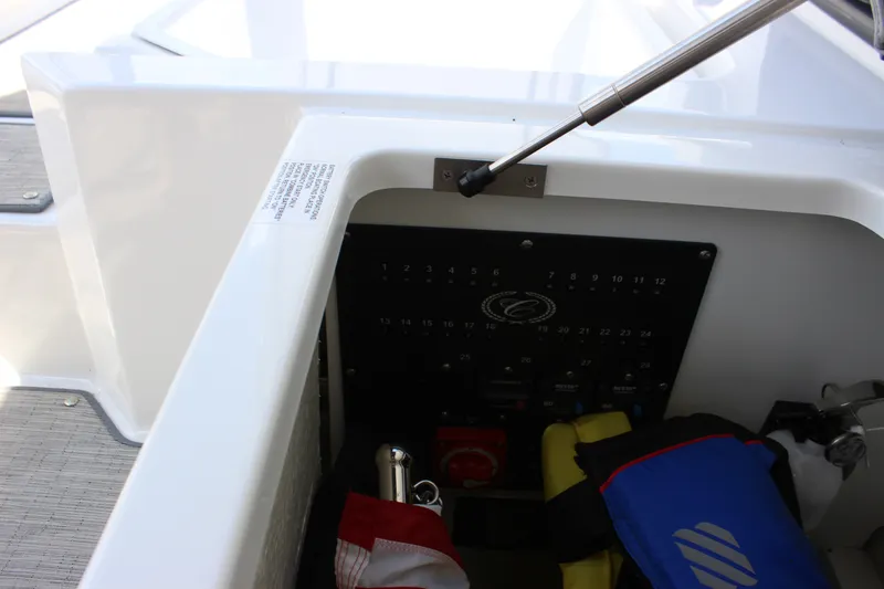 Slide: The Image of Storage compartment in 2024 Cobalt R6 Outboard boat, featuring safety equipment and control panel. - 35