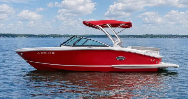 The Image of A red 2019 Cobalt CS23 boat on a calm lake under a blue sky. - 1